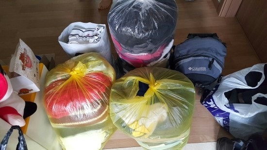 방 안에 봉투별로 모아둔 의류와 가방