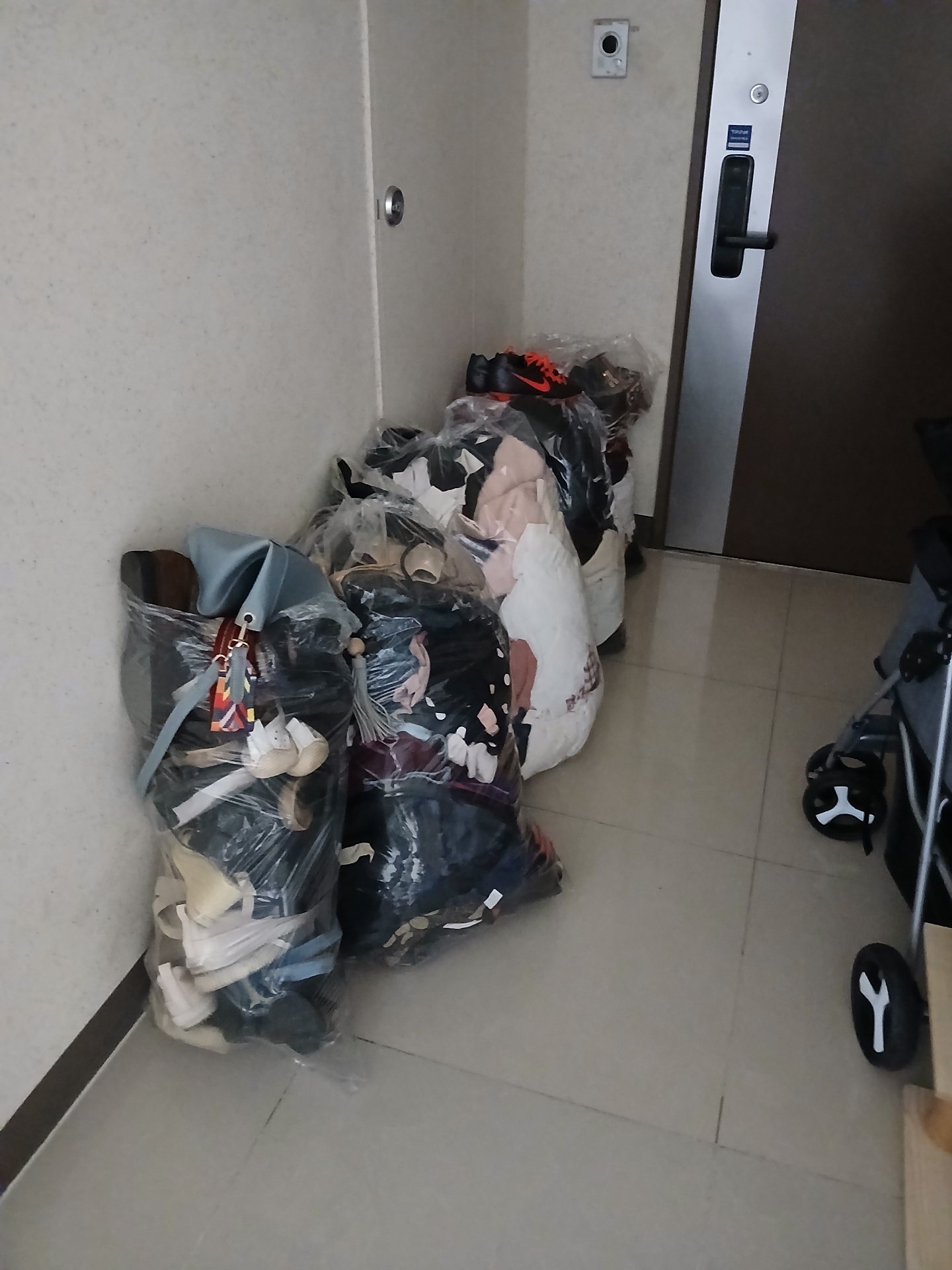 현관 안쪽에 가지런히 준비된 의류와 신발 봉투